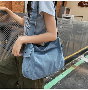 Detail showing denim canvas shoulder bag with utility side pocket and adjustable strap