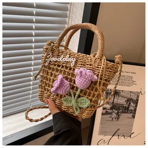 Detail of hand-woven straw bag with purple crochet flowers and Goodday embroidery