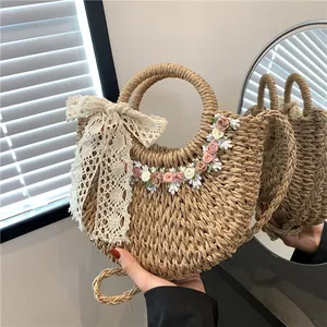 Borsa in paglia intrecciata con fiori e fiocco in pizzo per vacanze al mare e spiaggia