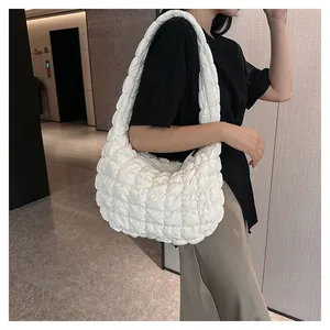 Close-up of white padded quilted shoulder bag featuring soft textured bubble fabric