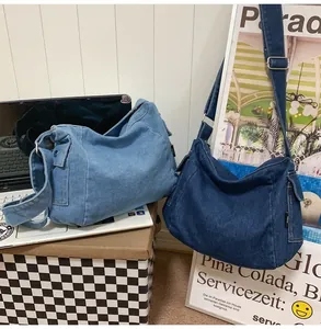 Detail of denim crossbody bags with side utility pockets and adjustable wide straps