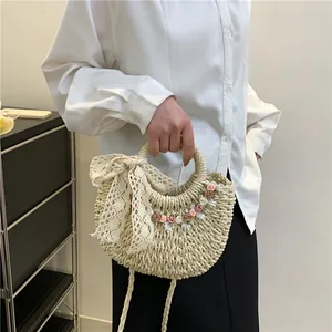 Borsa a mano in paglia intrecciata con fiori, fiocco in pizzo e fiori in tessuto