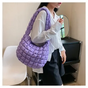 Detailed view of purple quilted cloud bag with puffy popcorn texture on female model