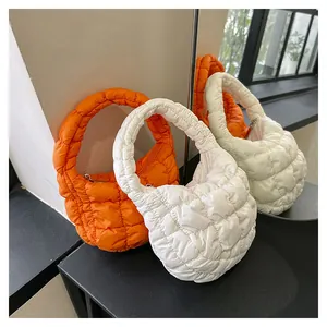 Detailed close-up of quilted puffy mini handbags in bright orange and white nylon colors
