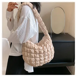 Detailed close-up of quilted puff shoulder bag in beige featuring soft pleated texture
