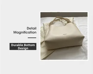 Detail of durable base design on minimalist cream leather tote bag with brand logo