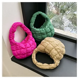 Detailed view of three quilted bubble handbags in rose, green, and beige colors