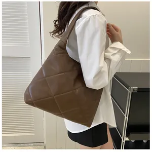 Detailed view of the large brown quilted pattern on the soft faux leather tote bag