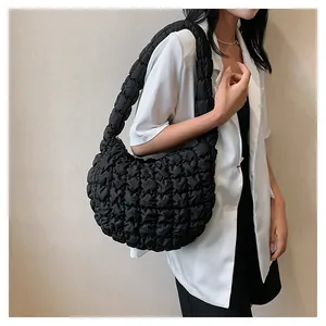 Detail view of the black quilted cloud bag with puffer pleated texture and crescent shape