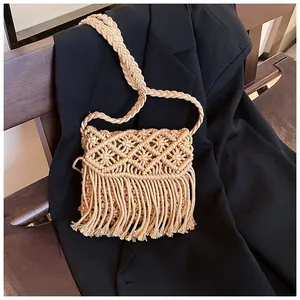 Close-up of bohemian woven straw bag showing intricate macrame patterns and long fringe detail