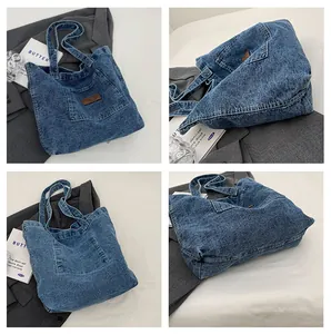 Detail view of washed denim tote bag showing leather patch and vintage texture
