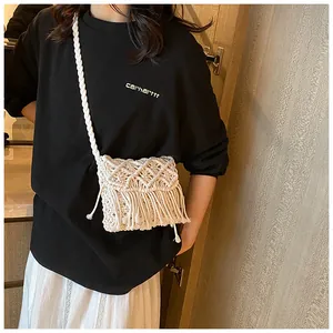 Detail of bohemian white woven shoulder bag with intricate diamond patterns and long tassels