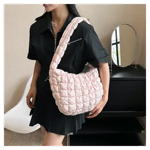 Detail of light pink quilted puffer bag showing the soft texture and puffy shoulder strap