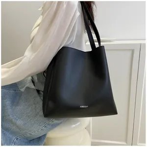 Close-up of minimalist black matte tote bag with shoulder strap and AIBEIDA logo