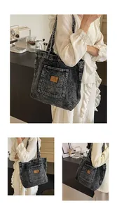 Detail of acid wash denim tote bag showing the front patch pocket and leather tag detail