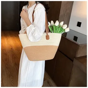 Detail of two-tone woven straw tote bag with brown leather straps and tulip decor
