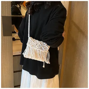 Detailed view of handmade white macrame crossbody bag with long tassels and woven strap