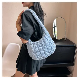 Sky blue quilted puff shoulder bag shown on model with stylish pleated texture