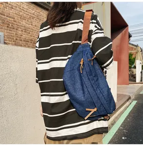 Κοντινό πλάνο μπλε τσάντας denim με καφέ δερμάτινα φερμουάρ και νάιλον ιμάντα ώμου