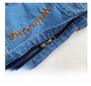 Detail showing smooth silver metal zipper and brown WISDORA embroidery on denim tote bag