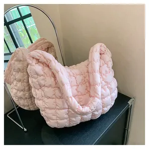 Detailed macro view of pink quilted puffer shoulder bag with soft padded texture