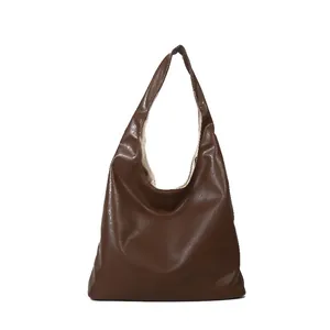 Minimalist large brown leather hobo shoulder bag with wide strap and soft textured finish