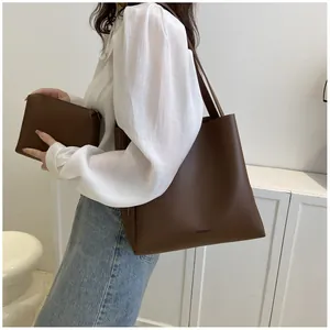 Detail of dark brown leather tote bag with matching inner pouch and shoulder strap