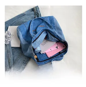 Spacious interior of denim tote bag showing tablet, umbrella and laptop storage
