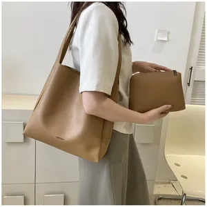 Detail of vintage brown tote bag set with matching inner pouch on minimalist background