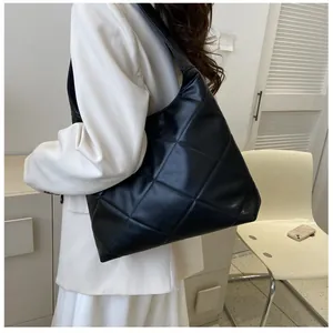 Chic black quilted tote bag displayed on model for a stylish daily commute look