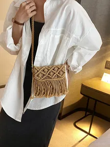 Bohemian woven straw crossbody bag with long fringes and geometric hollow patterns