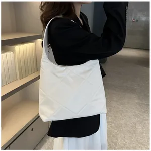 Minimalist white quilted hobo bag shown on shoulder for an elegant casual look