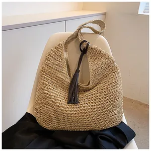 Close-up of woven straw shoulder bag featuring clear texture and dark brown tassel