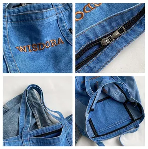 Detail view of denim tote bag showing embroidery logo, metal zipper and inner pocket