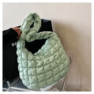 Detail of mint green quilted puffer shoulder bag showing bubble texture and nylon fabric