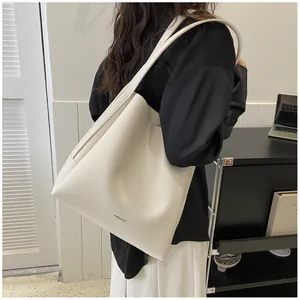 Macro detail of ivory PU leather tote bag with subtle minimalist brand logo engraving