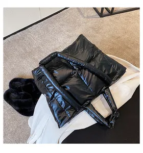Close-up of black quilted down tote bag showing plush texture on white knit background