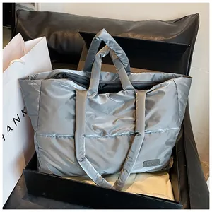 Dettaglio di una borsa tote trapuntata argento con finitura metallica lucida