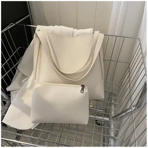 Detail view of cream leather tote bag and matching pouch inside a silver shopping cart