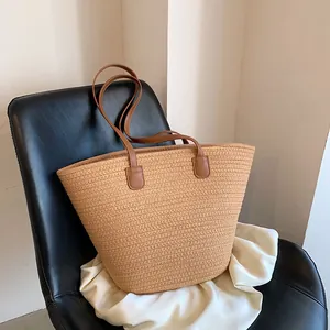 Large straw tote bag with brown leather straps for beach vacation and summer commute