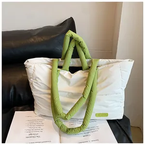 Dettaglio di una borsa tote trapuntata con manici verdi a contrasto ed etichetta fashion