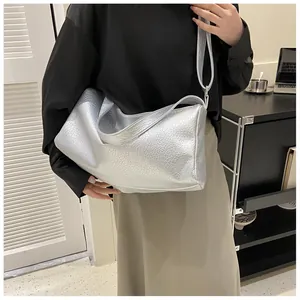 Détail du sac cabas en cuir argenté à motif crocodile avec texture métallique et zip