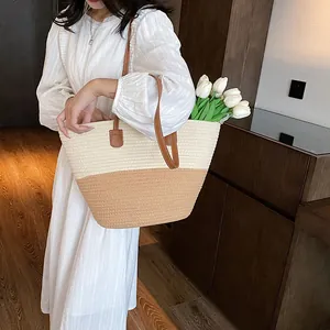 Large straw tote bag with brown leather handles and woven texture for beach and summer
