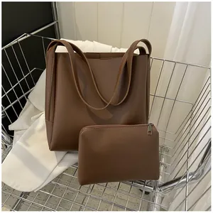 Close-up of brown PU leather tote bag set with matching zipper pouch in metal basket