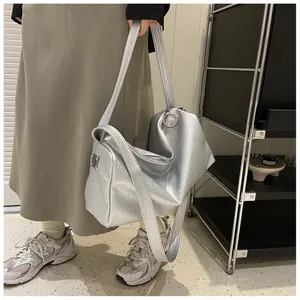Détails du sac cabas argenté avec texture métallisée et anneaux en métal élégants