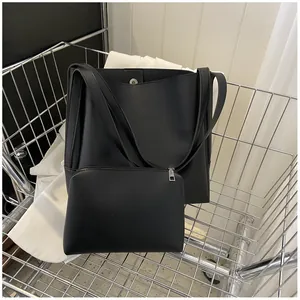 Close-up of black leather tote and pouch set inside a metallic shopping cart