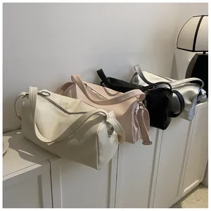 Vue détaillée de quatre sacs polochons minimalistes en cuir coloré sur un meuble