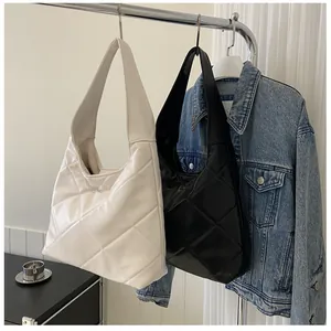 Quilted oversized hobo bag in black and white leather finish hanging on metal rack