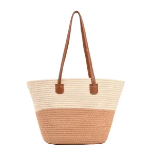 Two-tone woven straw tote bag with brown leather straps for summer beach vacations