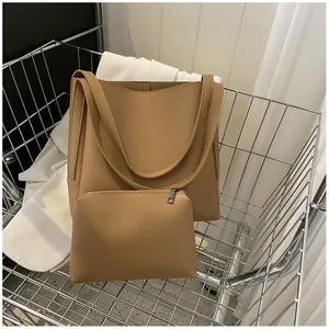 Detail of camel large tote bag and matching clutch pouch set in a stylish shopping cart